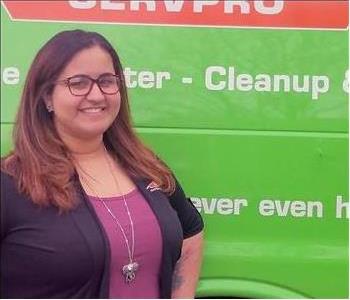 Female employee Bethanie Ocasio standing in front of a SERVPRO vehicle