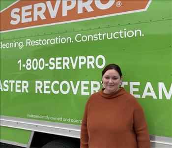Female employee Brittany Long standing in front of a SERVPRO vehicle