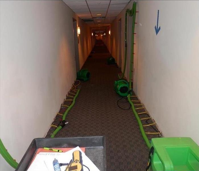 Drying a hallway after a storm caused water damage